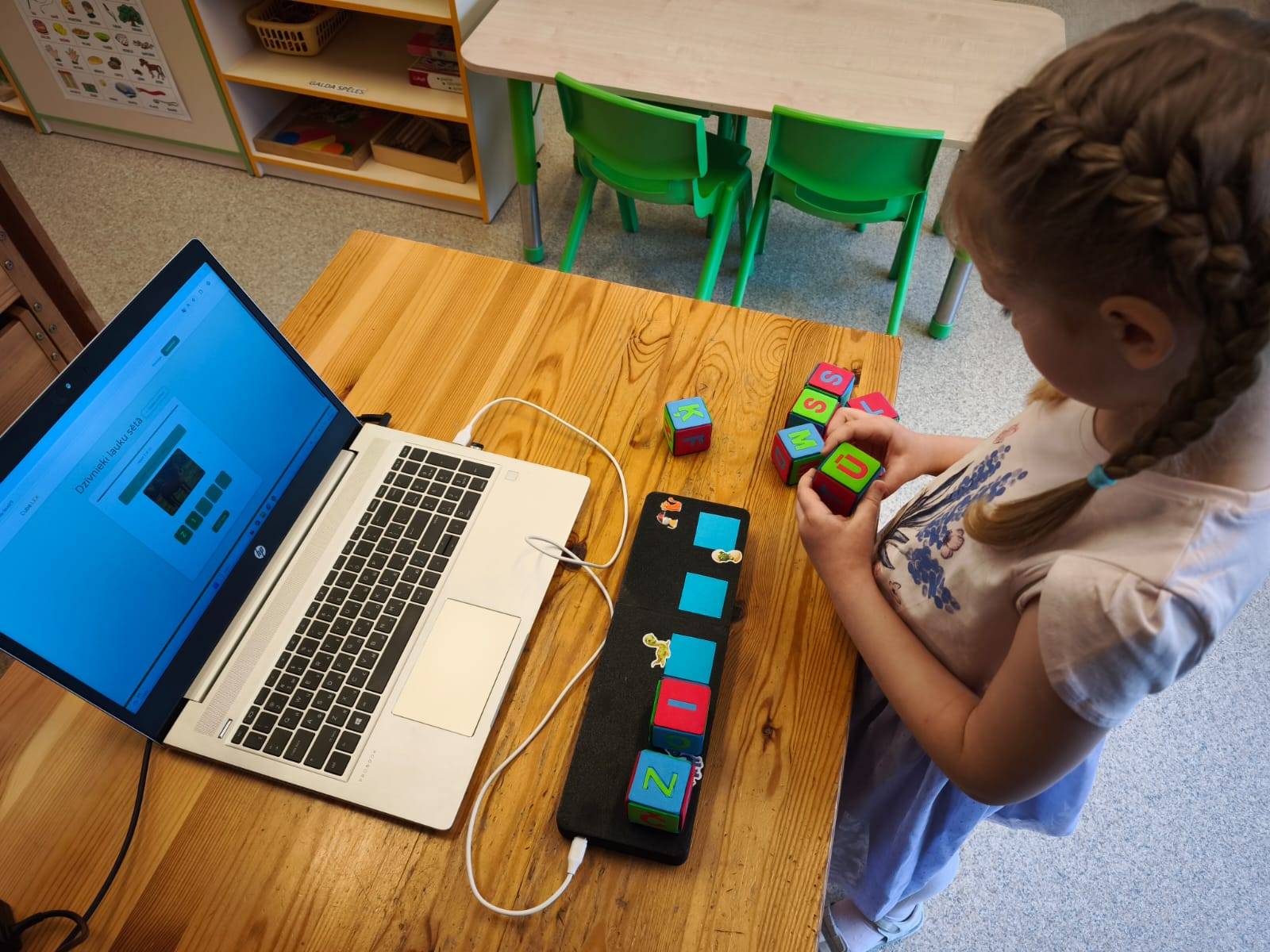 Bērns spēlē ar Cubelex burtu kubiņiem