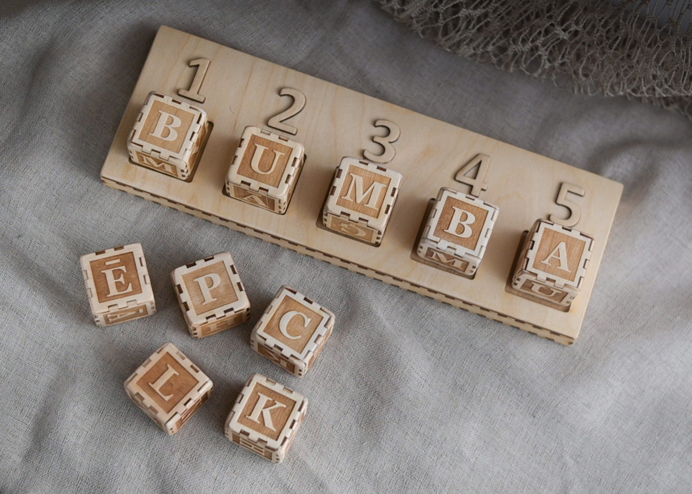 Bērns spēlē ar Cubelex burtu kubiņiem